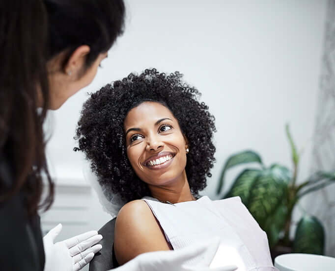 smiling woman talking with her dentist