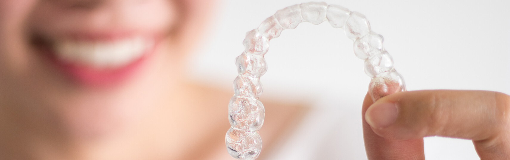 closeup of a person holding a clear aligner