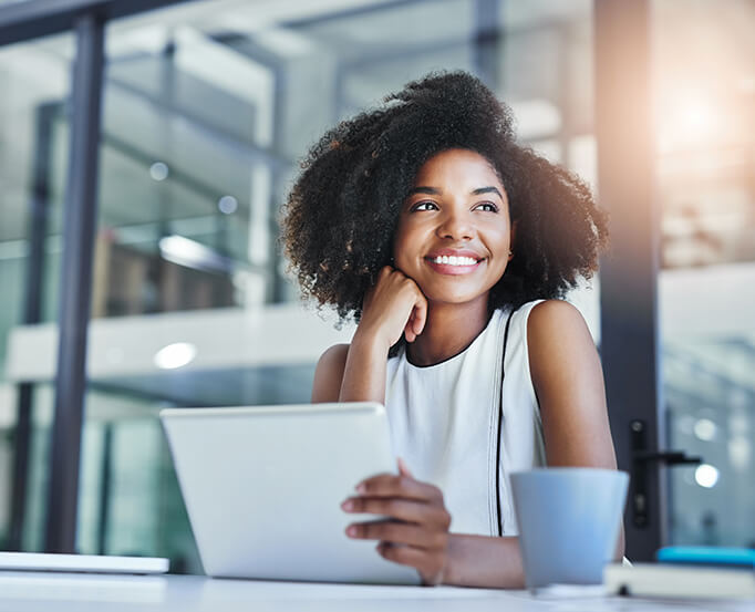 smiling woman sitting in front of a laptop