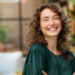 woman in green smiling at camera