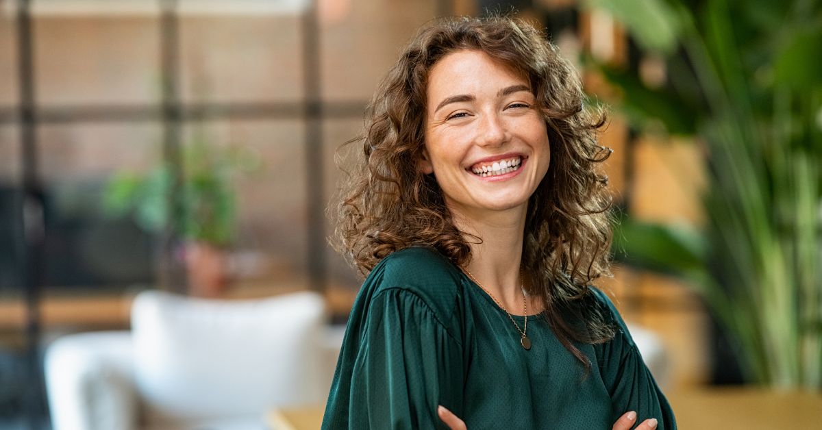 woman in green smiling at camera